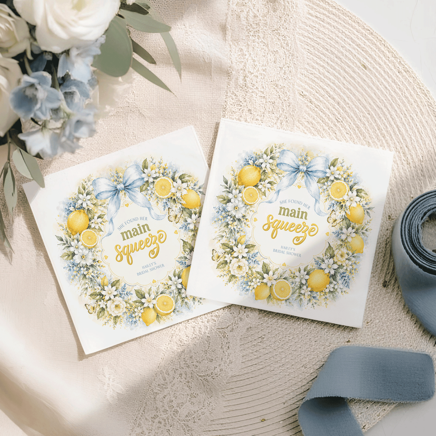 Two "She Found Her Main Squeeze" bridal shower invitations with lemon and floral wreaths.