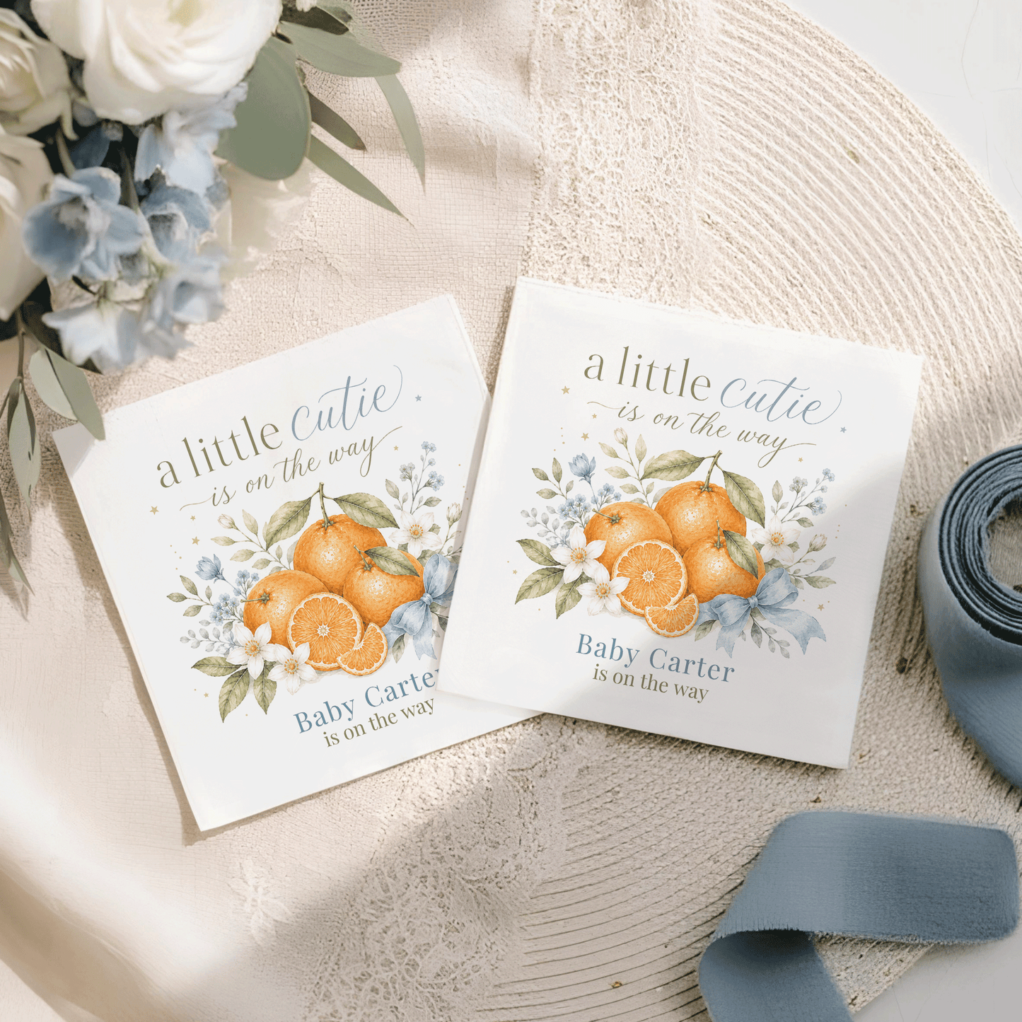 Two baby shower cards with "a little cutie is on the way" and orange illustrations.
