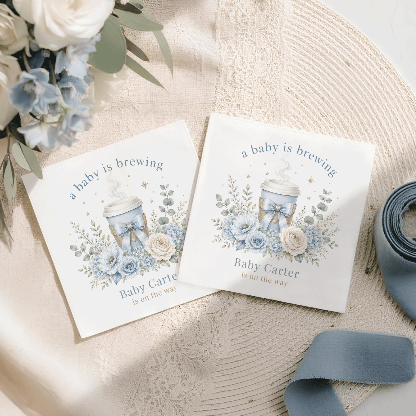 Two cards with "a baby is brewing" and blue floral design.