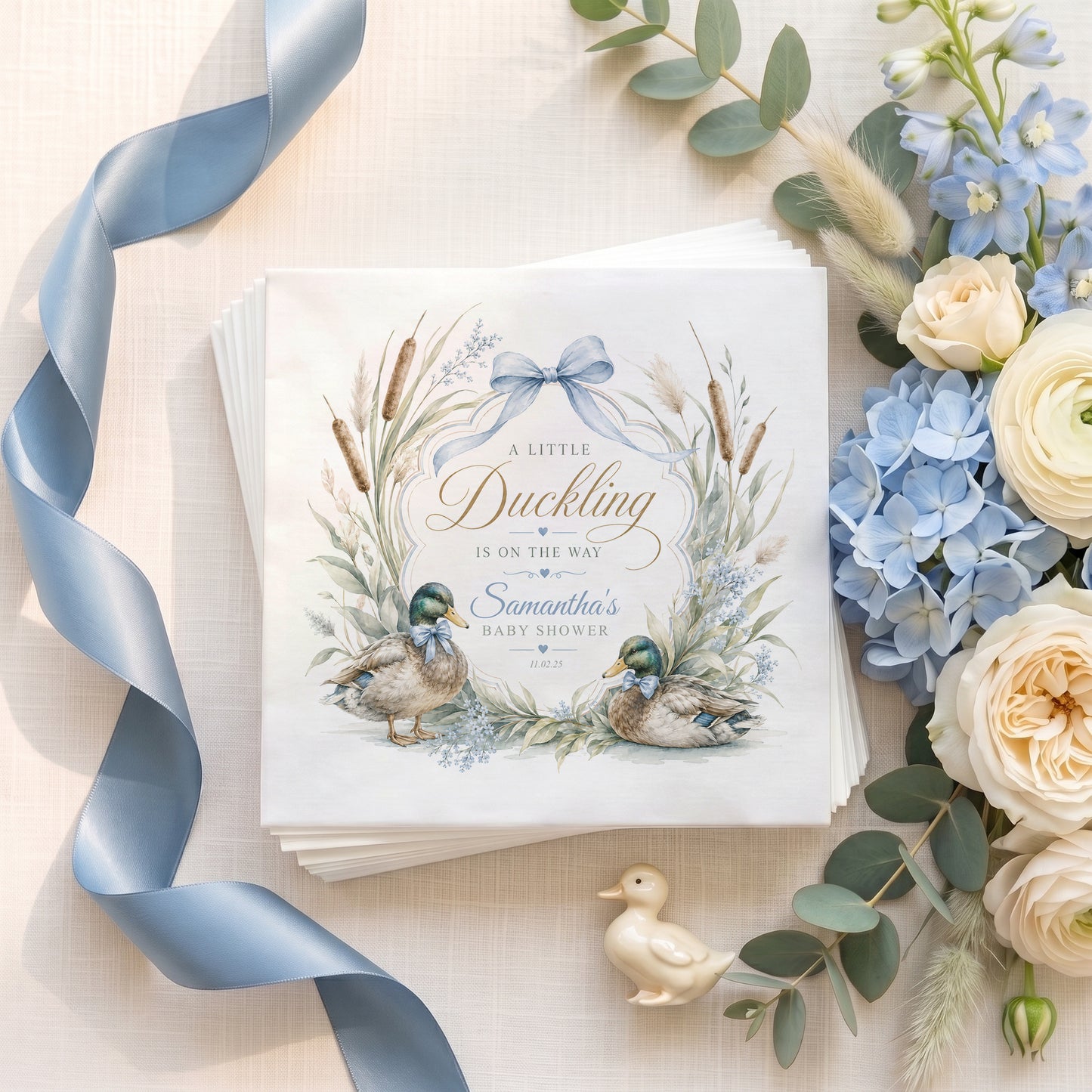 Personalized blue Little Duckling baby shower napkins with duck illustrations and ribbon crest