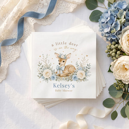 Dusty blue baby shower napkin with a fawn in a blue bow, blue roses, cream blooms and a personalized name in muted blue