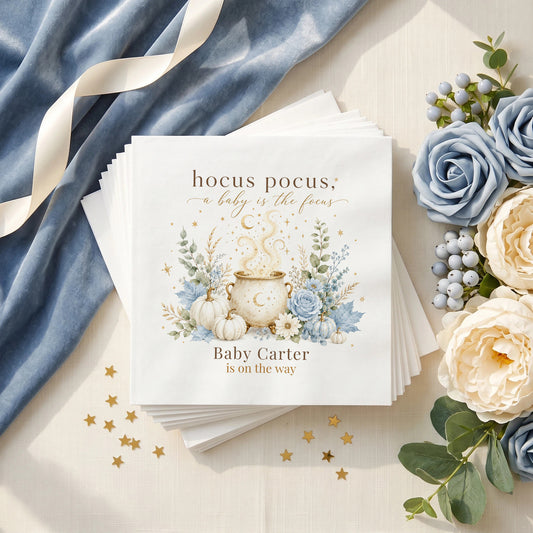 Dusty blue baby shower napkin with a gold moon cauldron, blue pumpkins, blue roses and a personalized baby name
