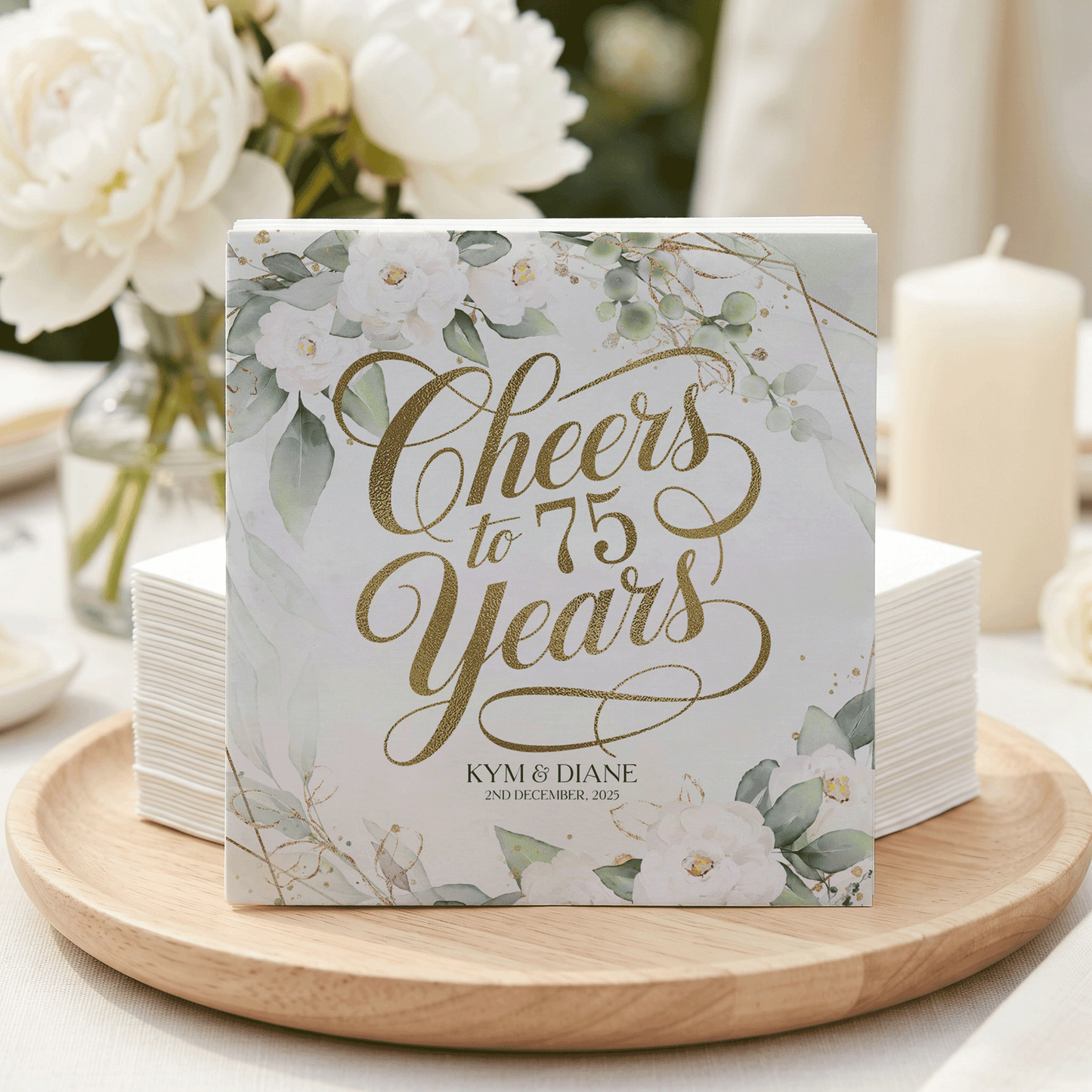 Cheers to 75 Years Kym & Diane on a card with floral and gold accents.