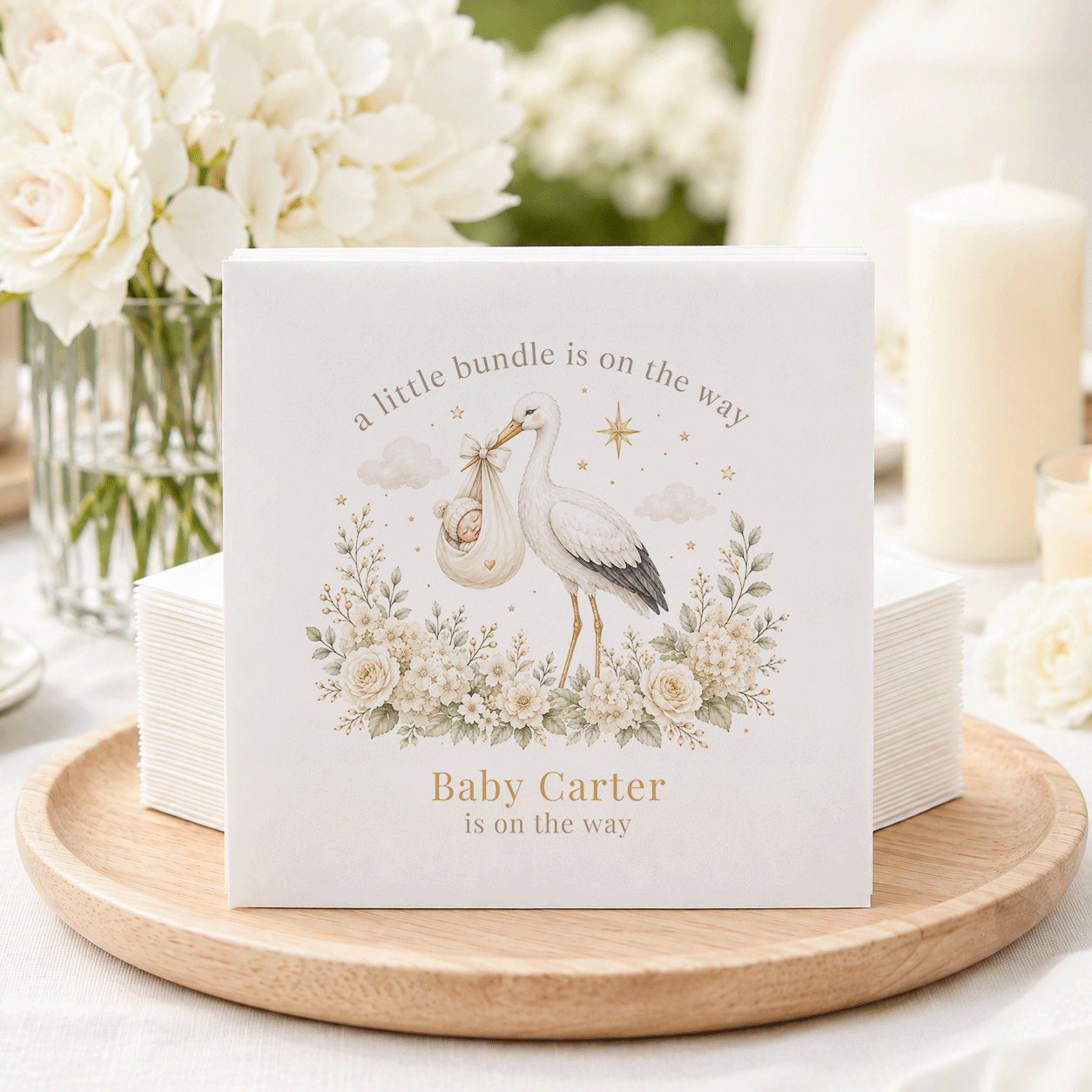 Baby shower napkins with a stork carrying a baby and text "Baby Carter is on the way."