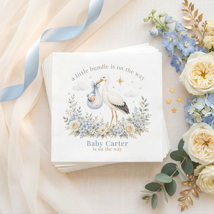 Personalized blue stork baby shower napkins with sleeping baby, floral details and custom event wording