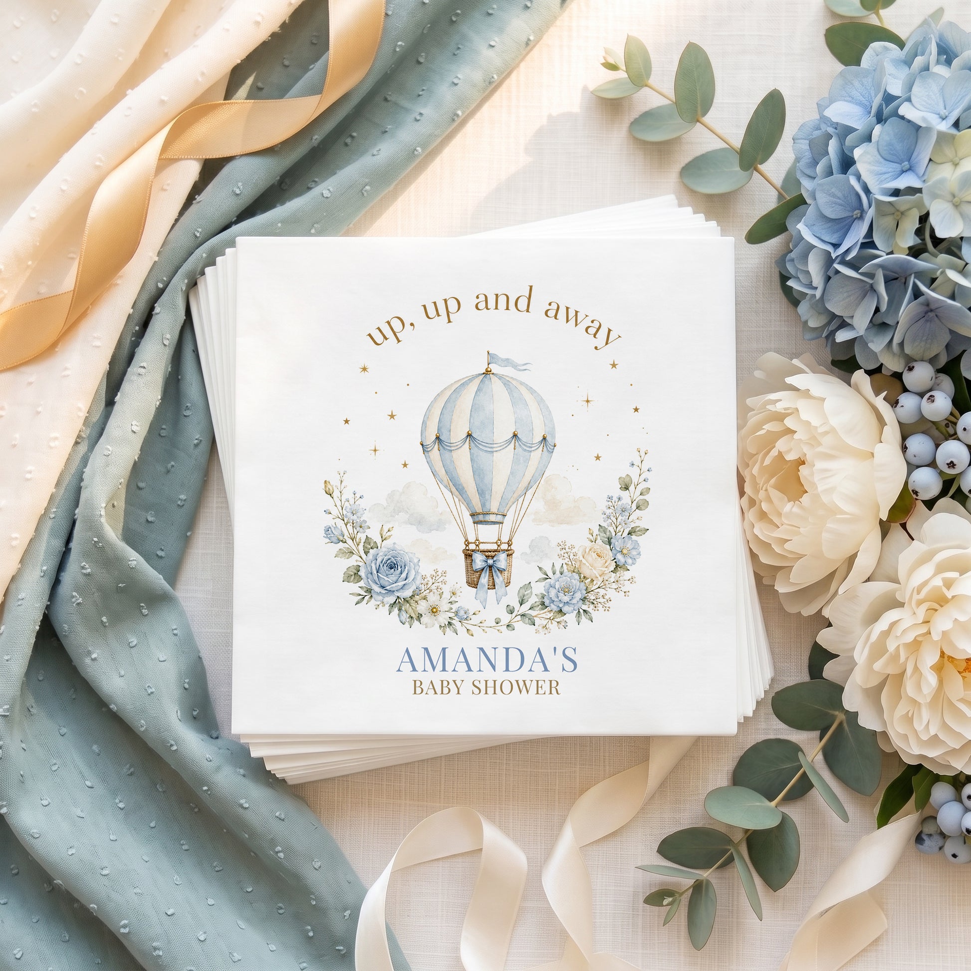 Dusty blue hot air balloon baby shower napkin with blue roses, gold stars and a personalized name in soft blue