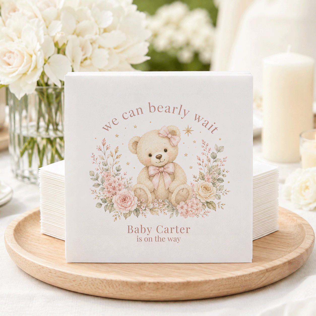 Baby shower napkins featuring a teddy bear, flowers, and "Baby Carter is on the way."
