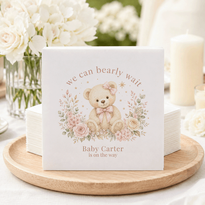 Baby shower napkins featuring a teddy bear, flowers, and "Baby Carter is on the way."