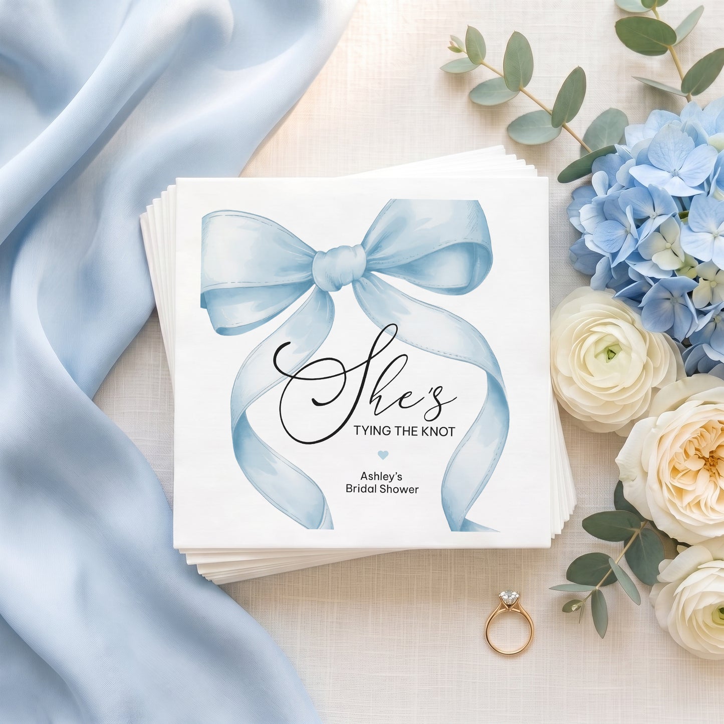 Personalized powder blue bow bridal shower napkins with She’s Tying the Knot wording and custom event details