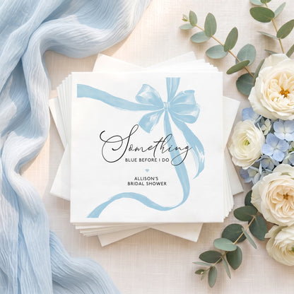 Personalized white bridal shower napkins with a pale blue bow and “Something Blue Before I Do” design for a bridal shower.