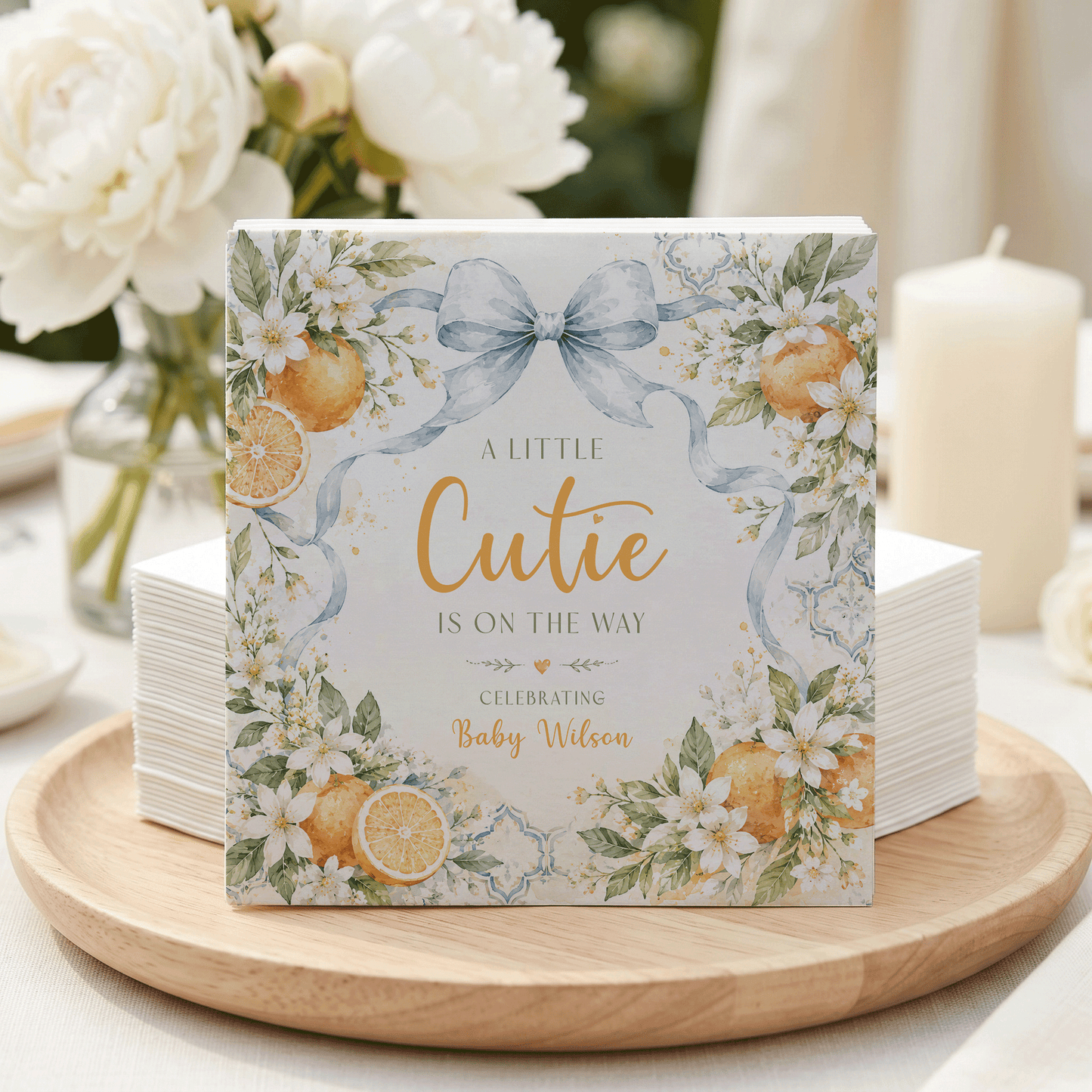 "A Little Cutie is on the Way" baby shower napkins with oranges and flowers.