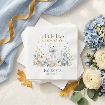 Dusty blue baby shower napkin with a ghost in a blue bow, white pumpkins, blue roses and a personalized name in muted blue