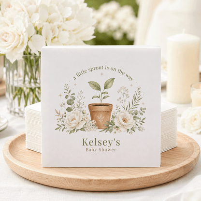 Baby shower napkins with a potted seedling and floral wreath, reading "Kelsey's Baby Shower."