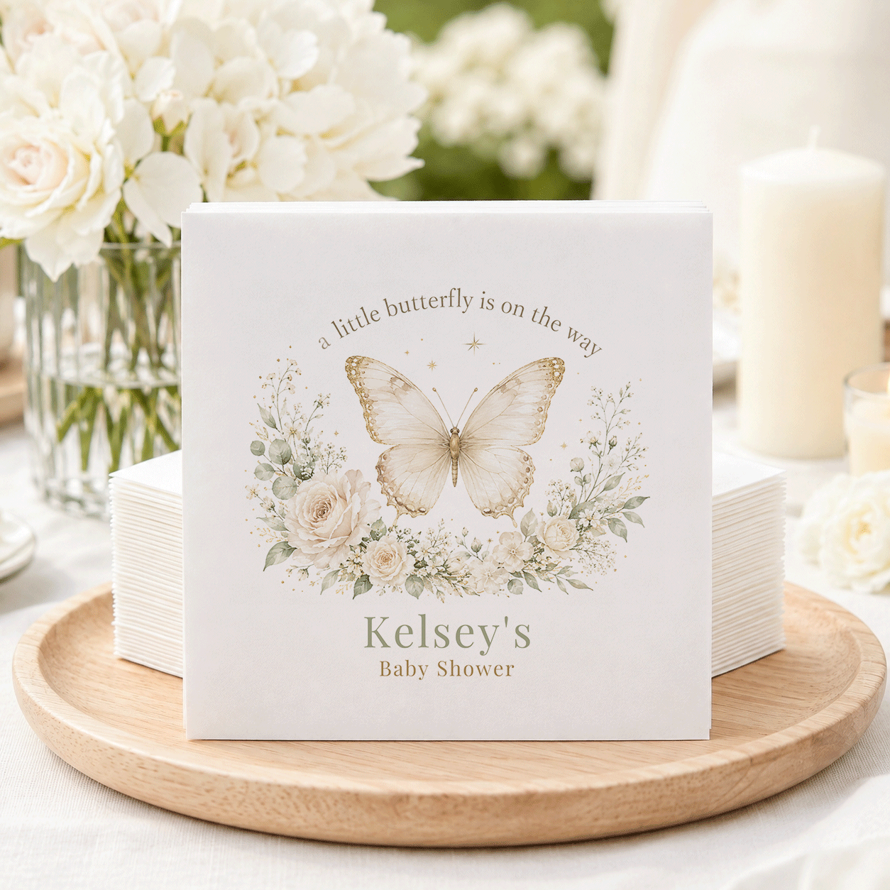 White baby shower napkins with a butterfly and floral design, reading "Kelsey's Baby Shower".