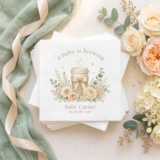 Personalized neutral A Baby Is Brewing baby shower napkins with coffee cup, ivory florals and custom event wording
