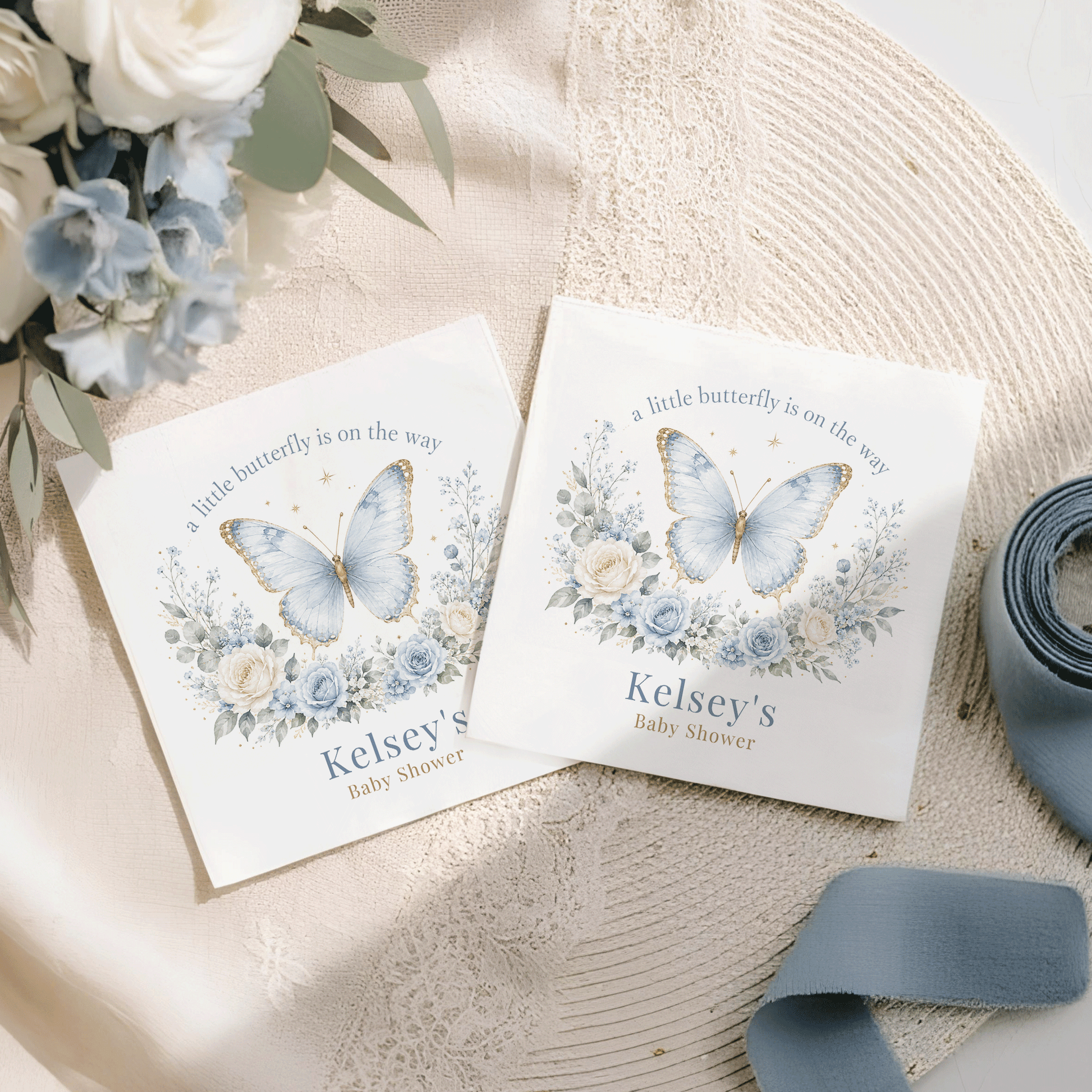 Two white cards with blue butterflies, flowers, and "Kelsey's Baby Shower" text.