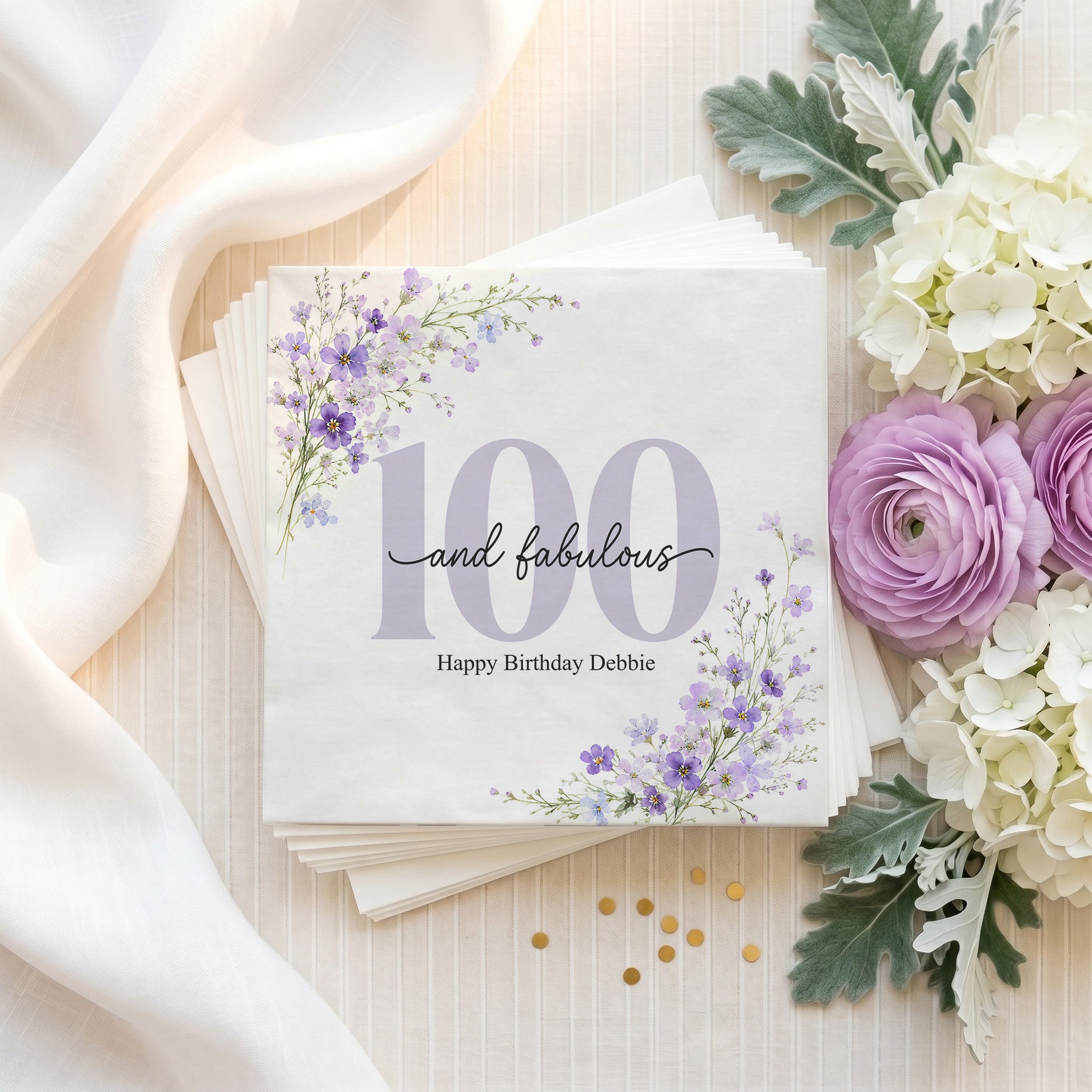 Napkins with purple flowers, "100 and fabulous" and "Happy Birthday Debbie".