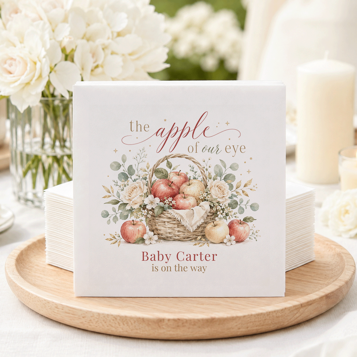 Napkins with a basket of apples illustration and text "Baby Carter is on the way."