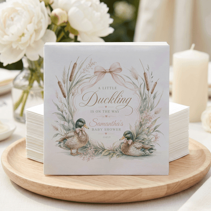 A Little Duckling baby shower invitation with two ducks and floral accents.