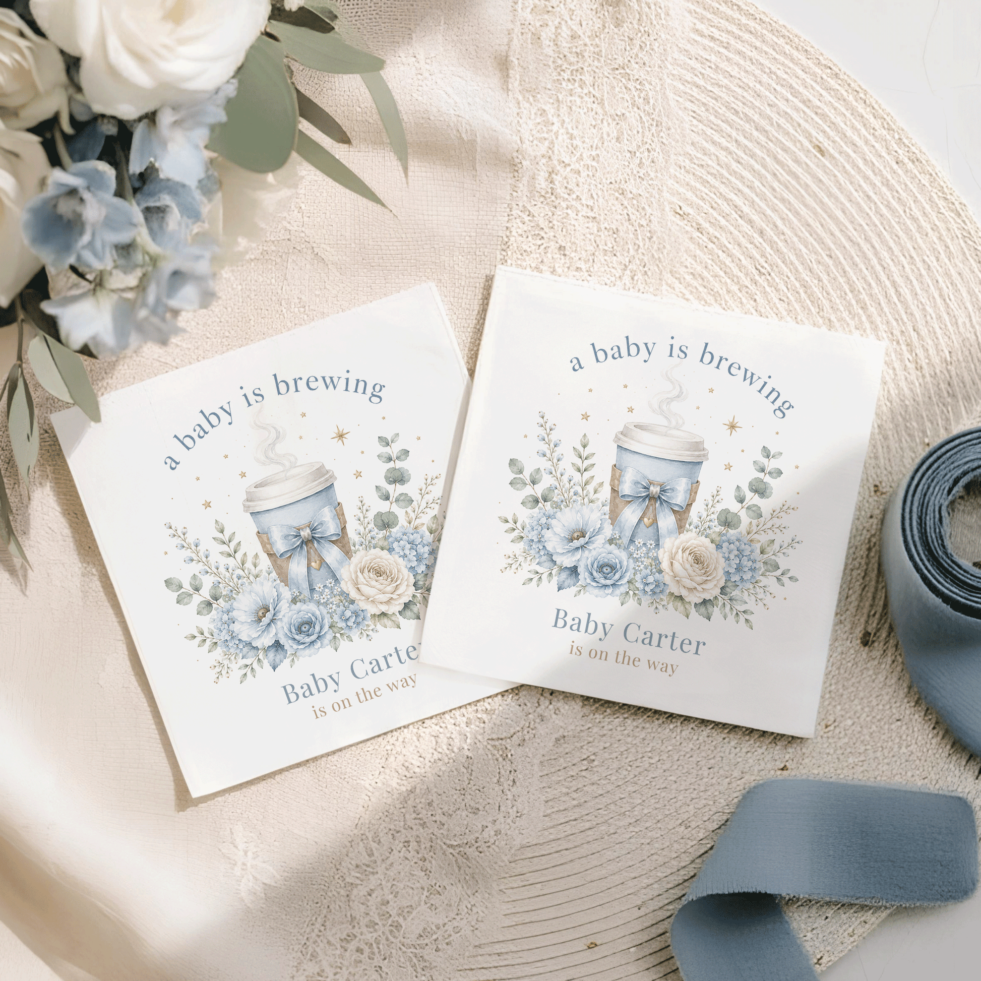 Two cards with "a baby is brewing" and blue floral design.