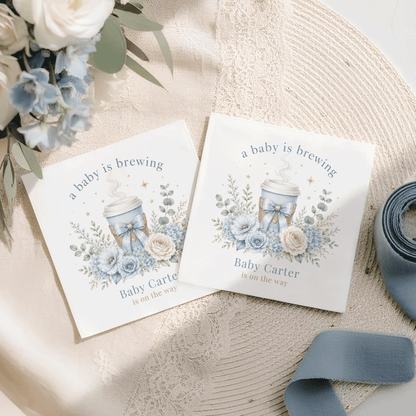 Two cards with "a baby is brewing" and blue floral design.